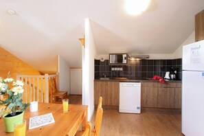 A compact kitchen with a microwave, dishwasher, and a refrigerator.