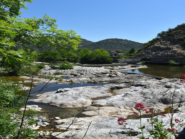 A natural landscape with a river, rocky terrain, and greenery.