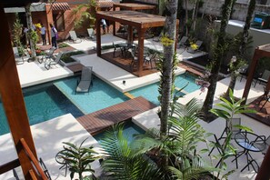 A pool area with lounge chairs, a wooden pergola, and a small pool. - Pousada do Rosa (São Sebastião)