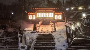 A traditional Japanese torii gate with a snow-covered pathway leading up to it. - Kinosato (Yamagata)