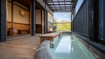 Ein traditionelles japanisches Onsen mit hölzernen Bänken und einer Steinterrasse.