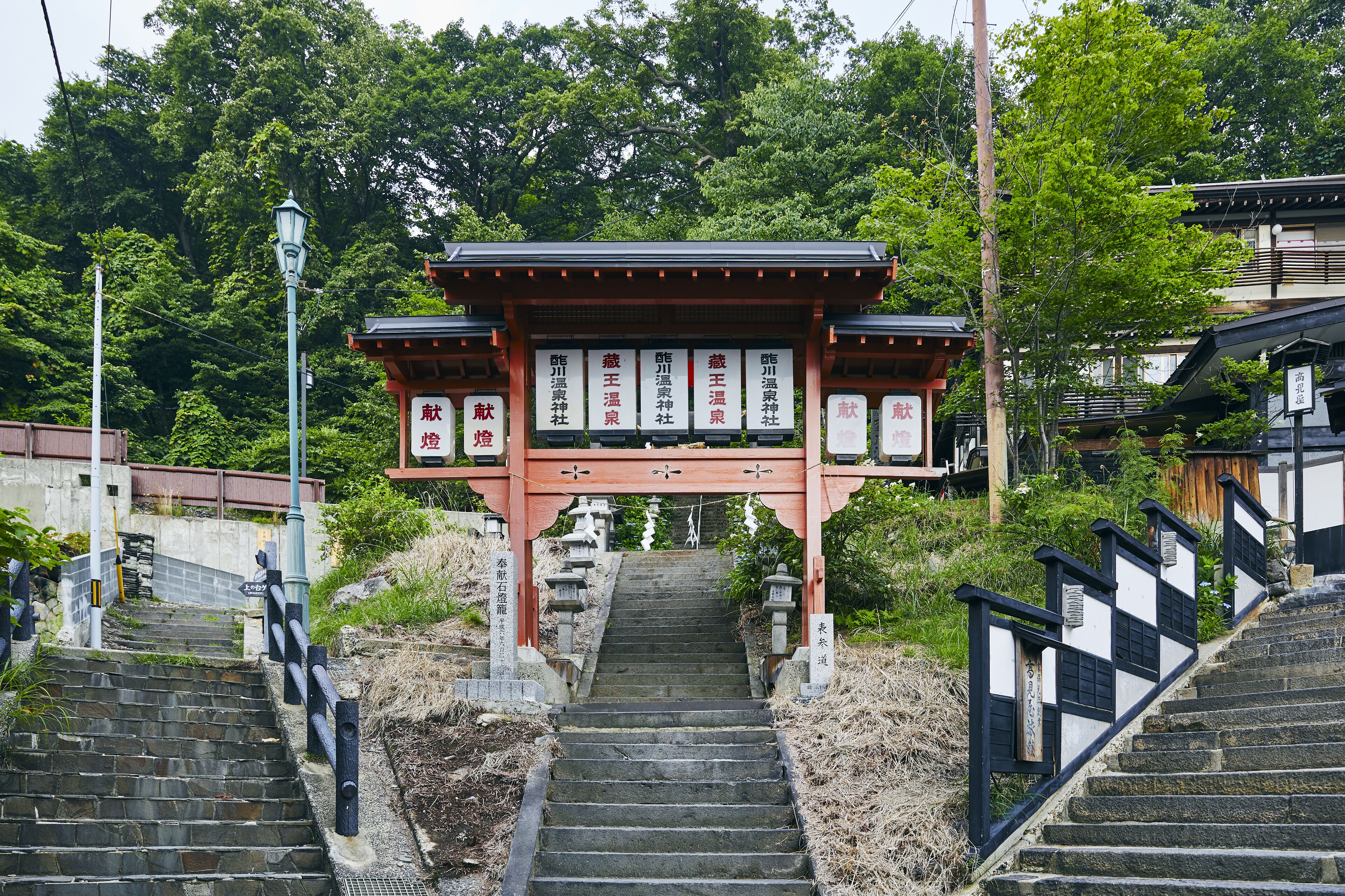 A traditional Japanese gate with stone steps leading up to it.
