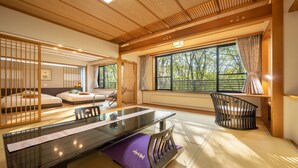A traditional Japanese-style room with tatami flooring, a low table, and a futon bed. - Kinosato (Yamagata)