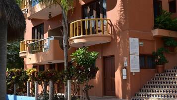 Un edificio con un balcone, una scala e una porta.