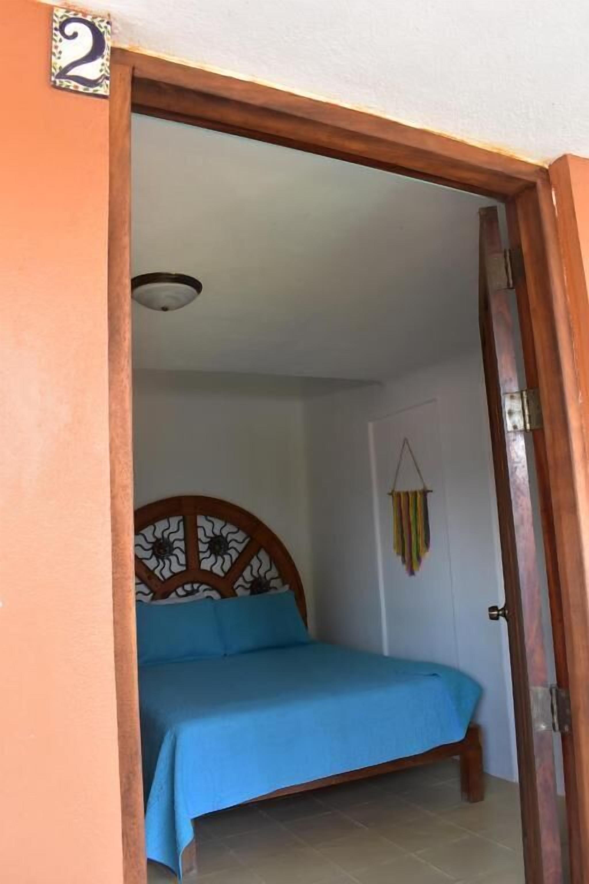 Un dormitorio con cama, una puerta con número y un adorno en la pared.