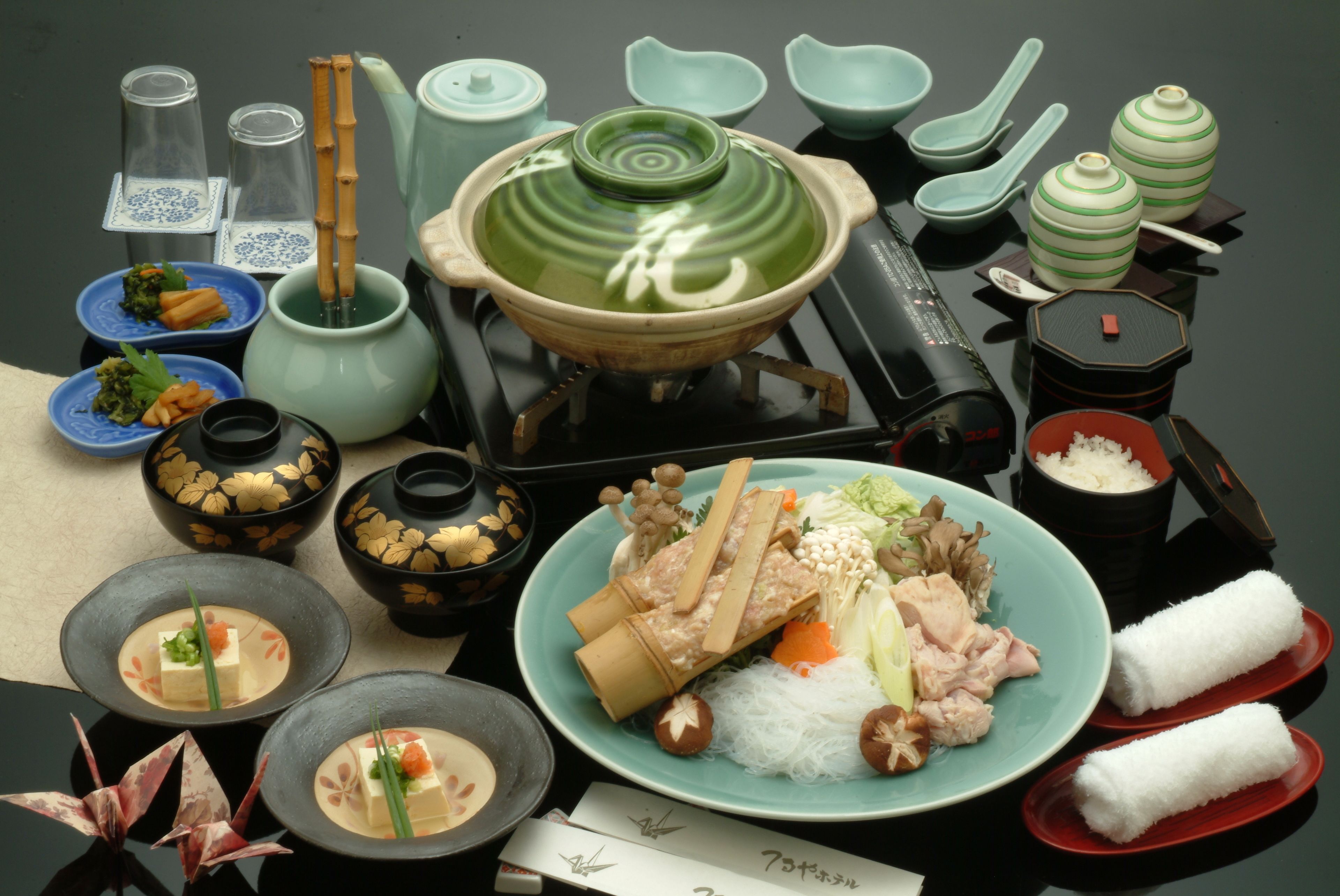 Una presentación tradicional de comida japonesa con diversos platos y utensilios.