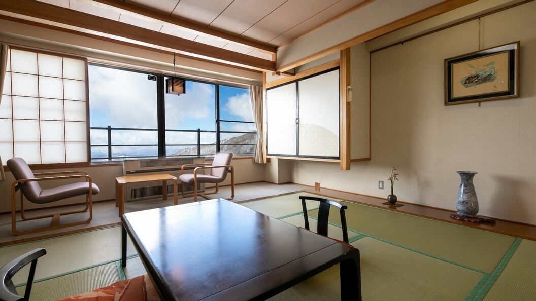 Una habitación japonesa tradicional con suelo de tatami, una mesa baja y sillas.