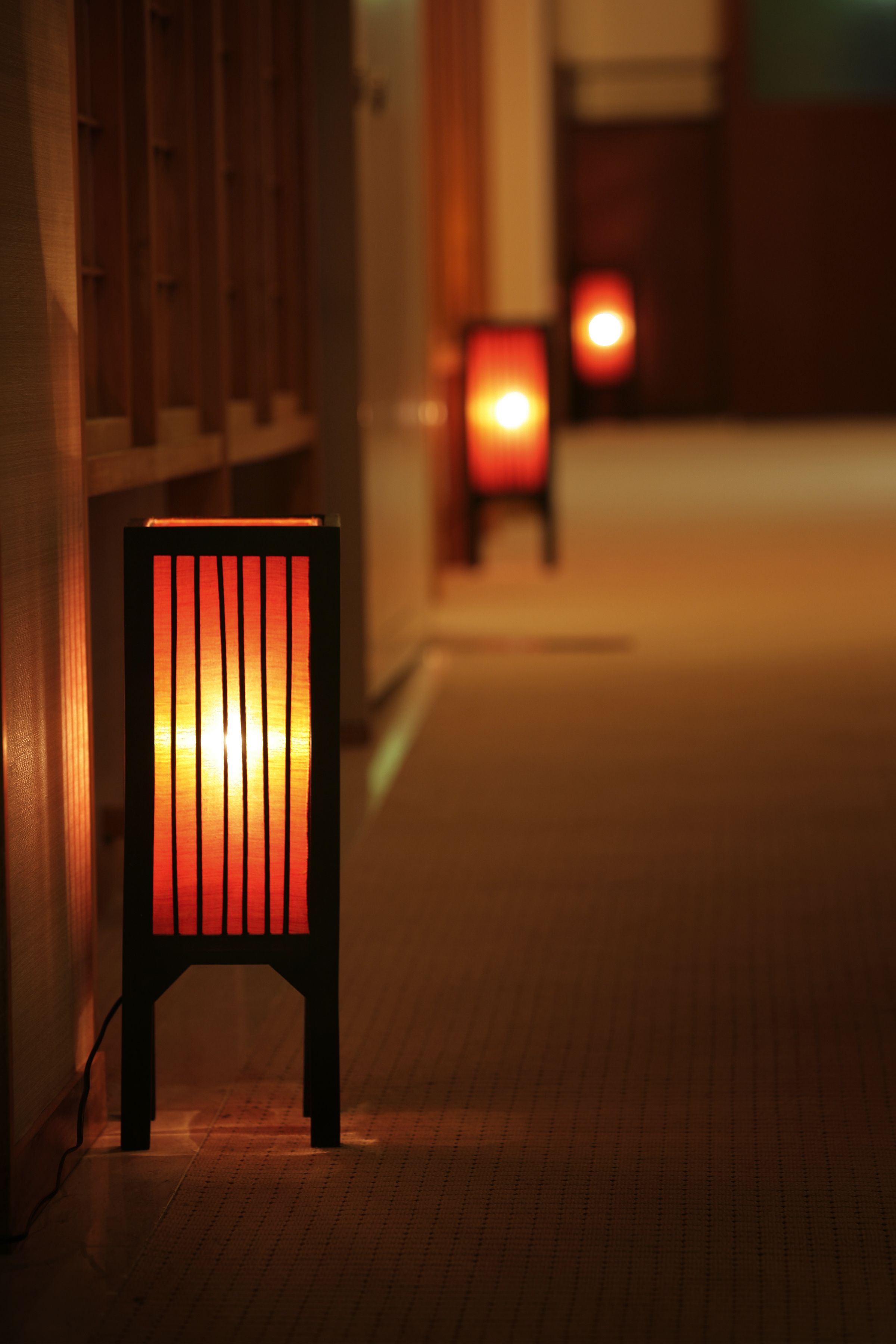 A chair with a glowing light source in a dimly lit corridor.