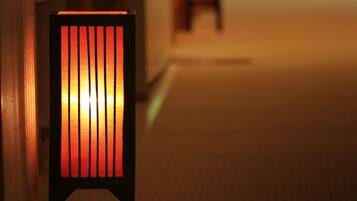 A chair with a glowing light source in a dimly lit corridor.
