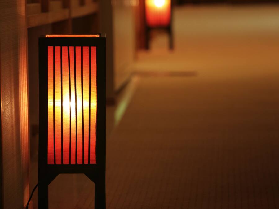 A chair with a glowing light source in a dimly lit corridor.