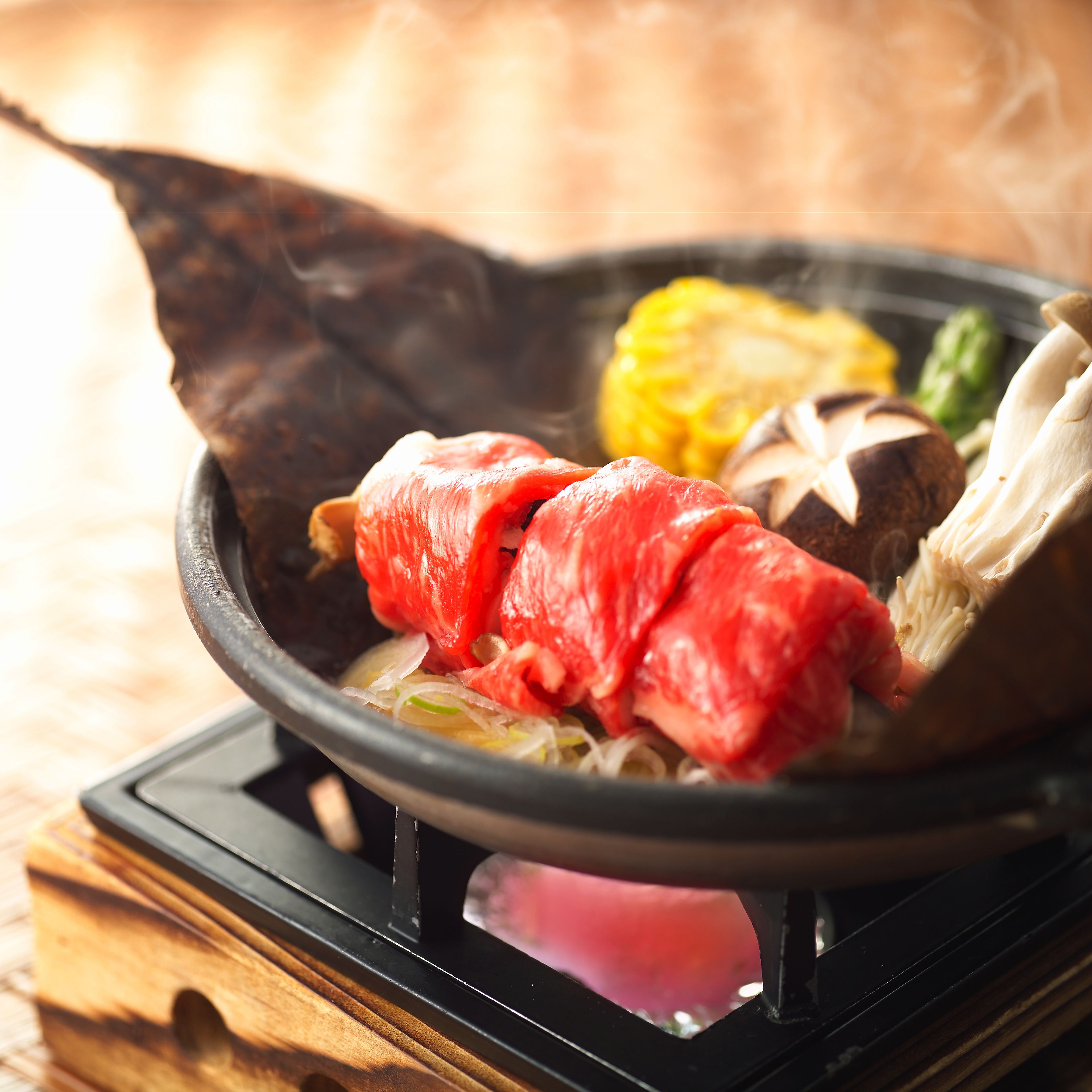 A hot pot with various ingredients including meat and vegetables.