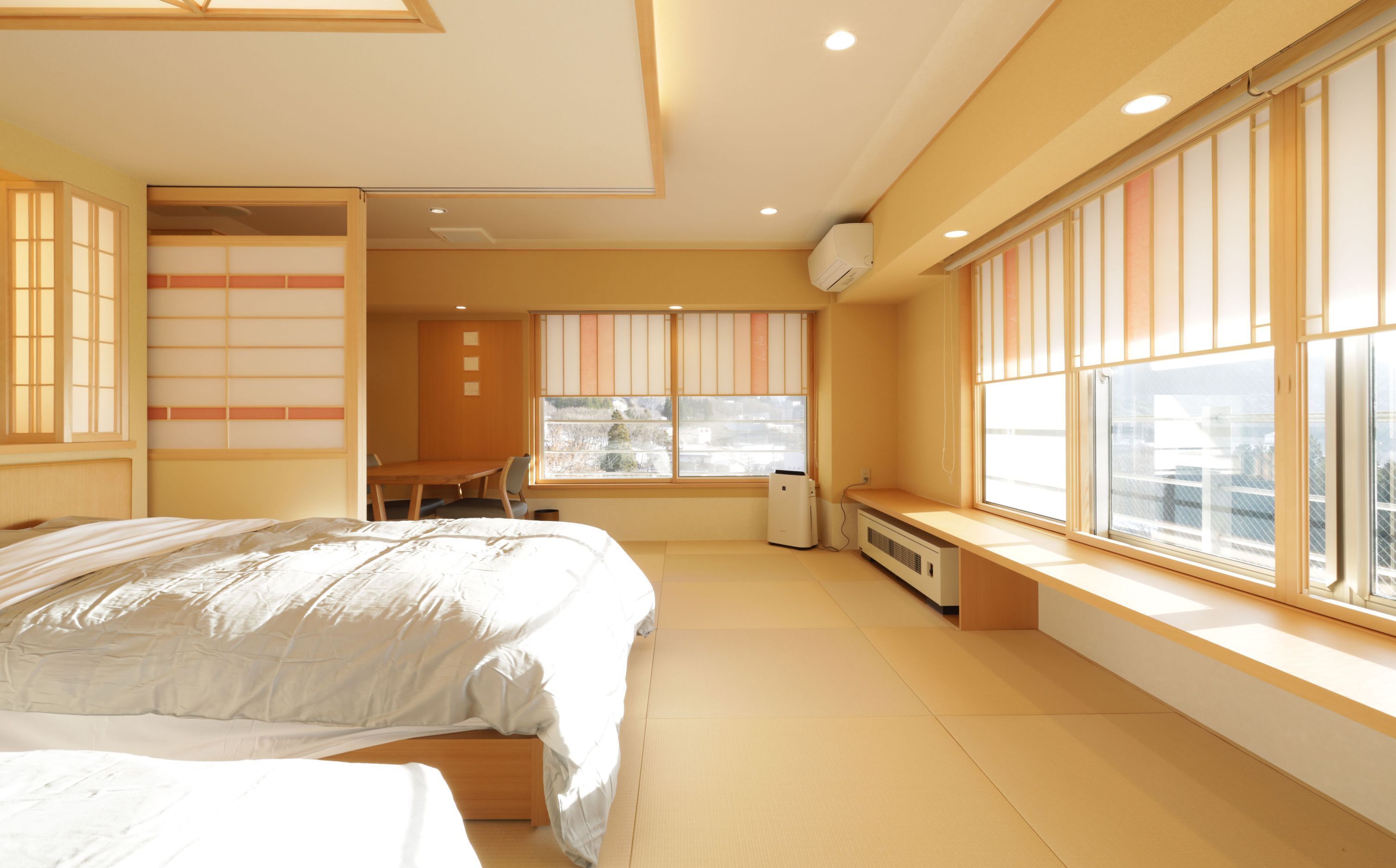 Un dormitorio con cama, escritorio y ventana con persianas.