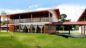 A modern two-story building with large windows and a covered outdoor area. - Hosteria Farallon (Sevilla Don Bosco)