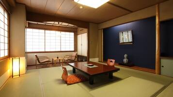 Una habitación japonesa tradicional con suelo de tatami, una mesa baja y sillas.