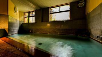 A public swimming pool with tiled walls and windows.