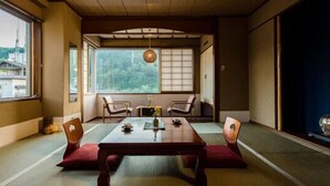 A traditional Japanese room with tatami flooring, a low table, and shoji screens. - Hotel Yamakawa (Yonezawa)