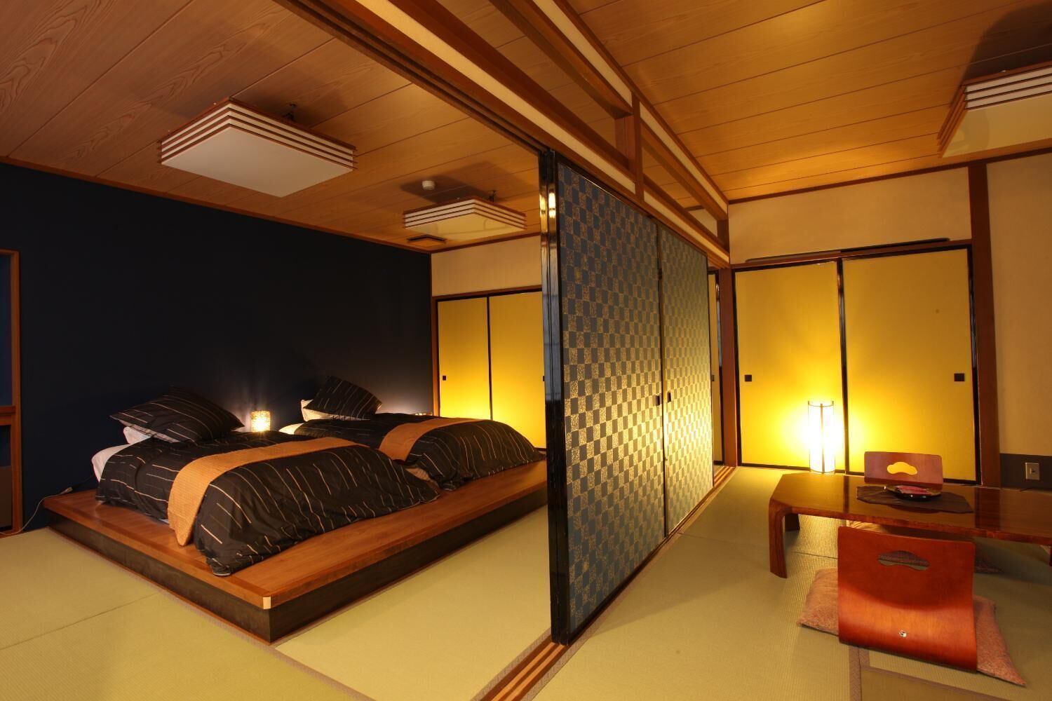 A traditional Japanese-style bedroom with tatami flooring, a low wooden bed, and sliding shoji screens.