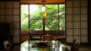 A traditional Japanese-style room with tatami flooring, a low table, and sliding doors. - Hotel Yamakawa (Yonezawa)