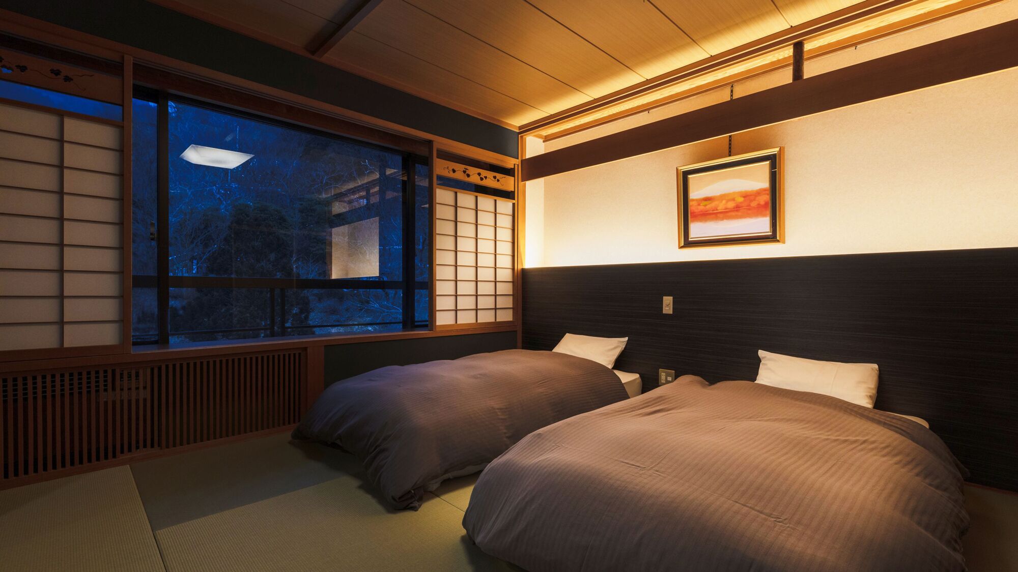 A traditional Japanese-style room with tatami flooring, a shoji screen window, and a bed with a dark headboard.