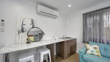 A compact living space with a kitchen area, a sofa, and a dining table.