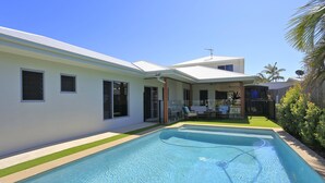 A modern house with a swimming pool, a covered patio, and a fenced backyard. - 12th Tee Bed and Breakfast (Bargara)