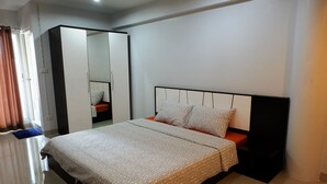 A neatly arranged bedroom with a bed, a wardrobe, and a mirror. - Casa Blanca (Bangkok)