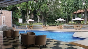 A pool area with checkered flooring, lounge chairs, and umbrellas. - De Ningrat Topas Galeria (Bandung)