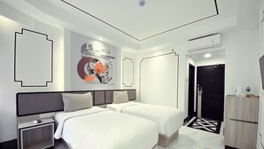 A modern hotel room with two beds, a large mirror, a wall art piece, and a black and white patterned rug. - De Ningrat Topas Galeria (Bandung)