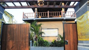 A gated entrance with a wooden gate, a signboard, and a balcony with a view of the surroundings. - Menjangan Sari (Pejarakan)