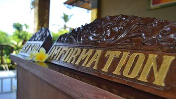 A wooden reception desk with carved details and the words "Information" prominently displayed.