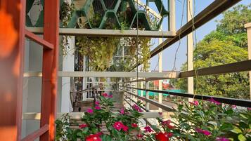 A balcony with a view of a building and greenery.