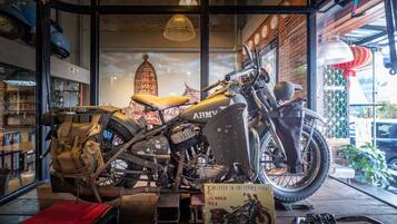 Une moto ancienne est exposée dans la vitrine d’un magasin, avec une pancarte indiquant qu’elle est présentée dans le catalogue « Freedom’s Fight ».