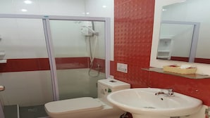 Ein Badezimmer mit einer Duschkabine, einer weißen Toilette und einem weißen Waschbecken.