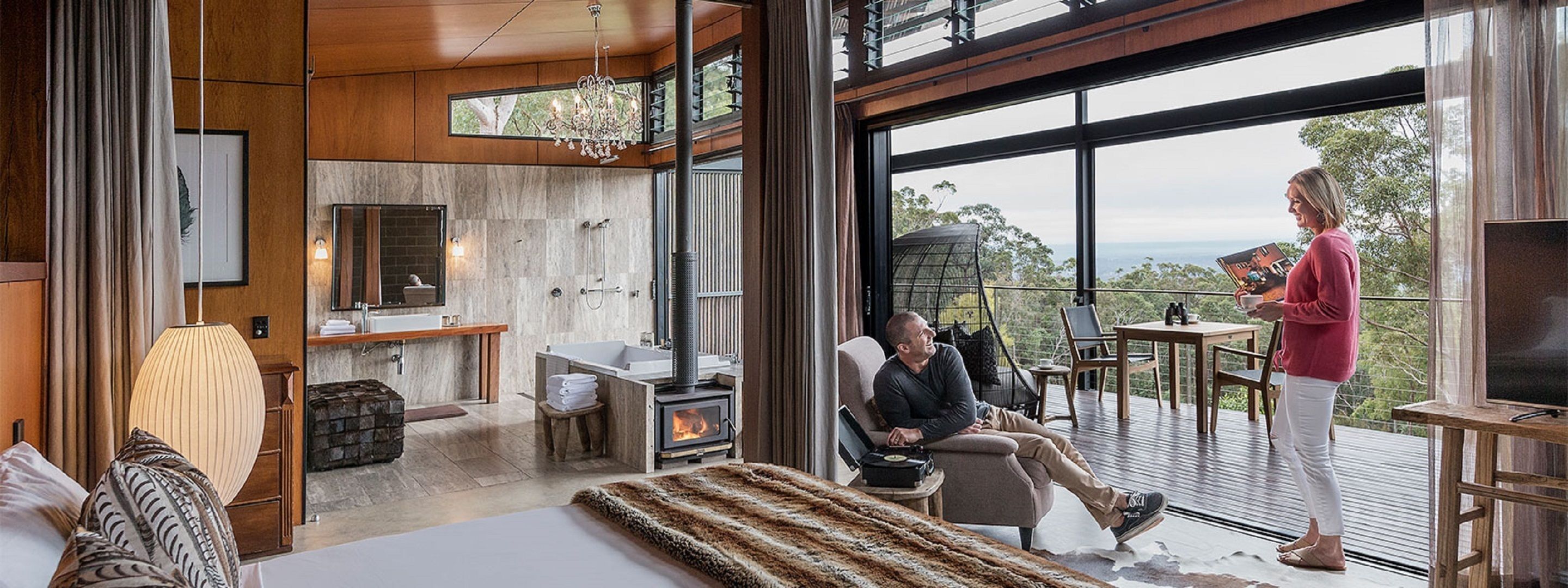 A modern interior with a fireplace, a large window, and a balcony.