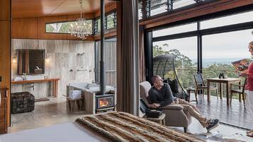 A modern interior with a fireplace, a large window, and a balcony.
