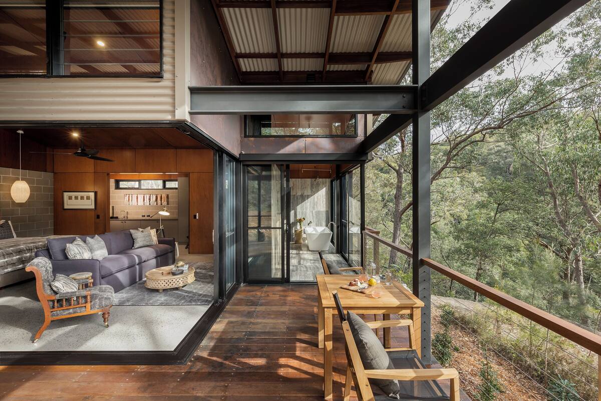 Un intérieur moderne avec un plancher en bois, un canapé, une table à manger et une vue sur l’extérieur.