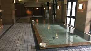 A long indoor swimming pool with tiled floors and walls, large windows on one side, and a few bowls on the poolside. - Nanki Shirahama Golf Club, Nanki Shirahama Resort Hotel (Kamitonda)
