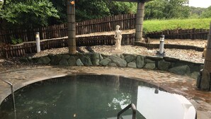 A circular pool with a stone border, a statue, and a wooden fence in the background. - Nanki Shirahama Golf Club, Nanki Shirahama Resort Hotel (Kamitonda)
