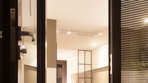 A modern hotel room with a large bathtub, a separate bedroom with a bed, and a bathroom with a mirror and sink. - Hotel Gaden by Onyu stay (Suwon)