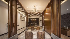 A modern lobby with a central seating area, wooden accents, and a chandelier. - Fishman homestay (Hangzhou)