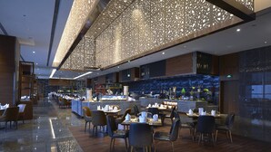 Un restaurante moderno con zona de bar, suelo de madera y techo decorativo.