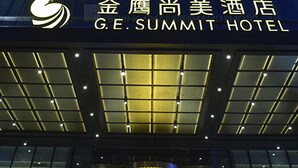 Un edificio alto con fachada de vidrio moderna y un letrero del Hotel GE Summit.
