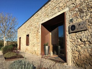 A stone building with an open entrance, a sign reading "AGVA VILA", and a potted plant outside. - Acquavilla House (Pombal)