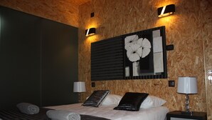 A modern bedroom with a wooden headboard, a large bed with multiple pillows, two bedside lamps, and a wall-mounted artwork. - Acquavilla House (Pombal)