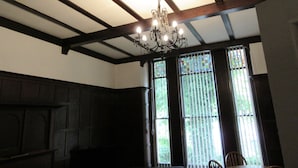 A room with a high ceiling, exposed wooden beams, a chandelier, and large windows with vertical blinds. - Aigburth Apartments - Ivanhoe (Liverpool)