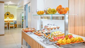 Un bufé con diversas opciones de comida y un área de estar al fondo.