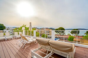 A deck with white lounge chairs and a view of the sea. - Cupido Boutique Hotel (Calvia)