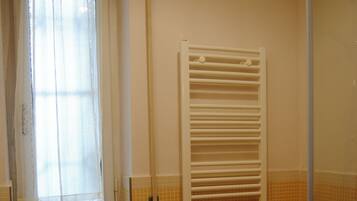 Ein Badezimmer mit Waschbecken, Bidet und einem Fenster mit Vorhang.