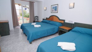 A hotel room with two beds, a chair, a desk, and a window with curtains.