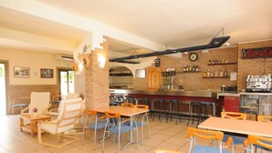 A restaurant with brick walls, a bar area, and multiple seating options including tables and chairs.
